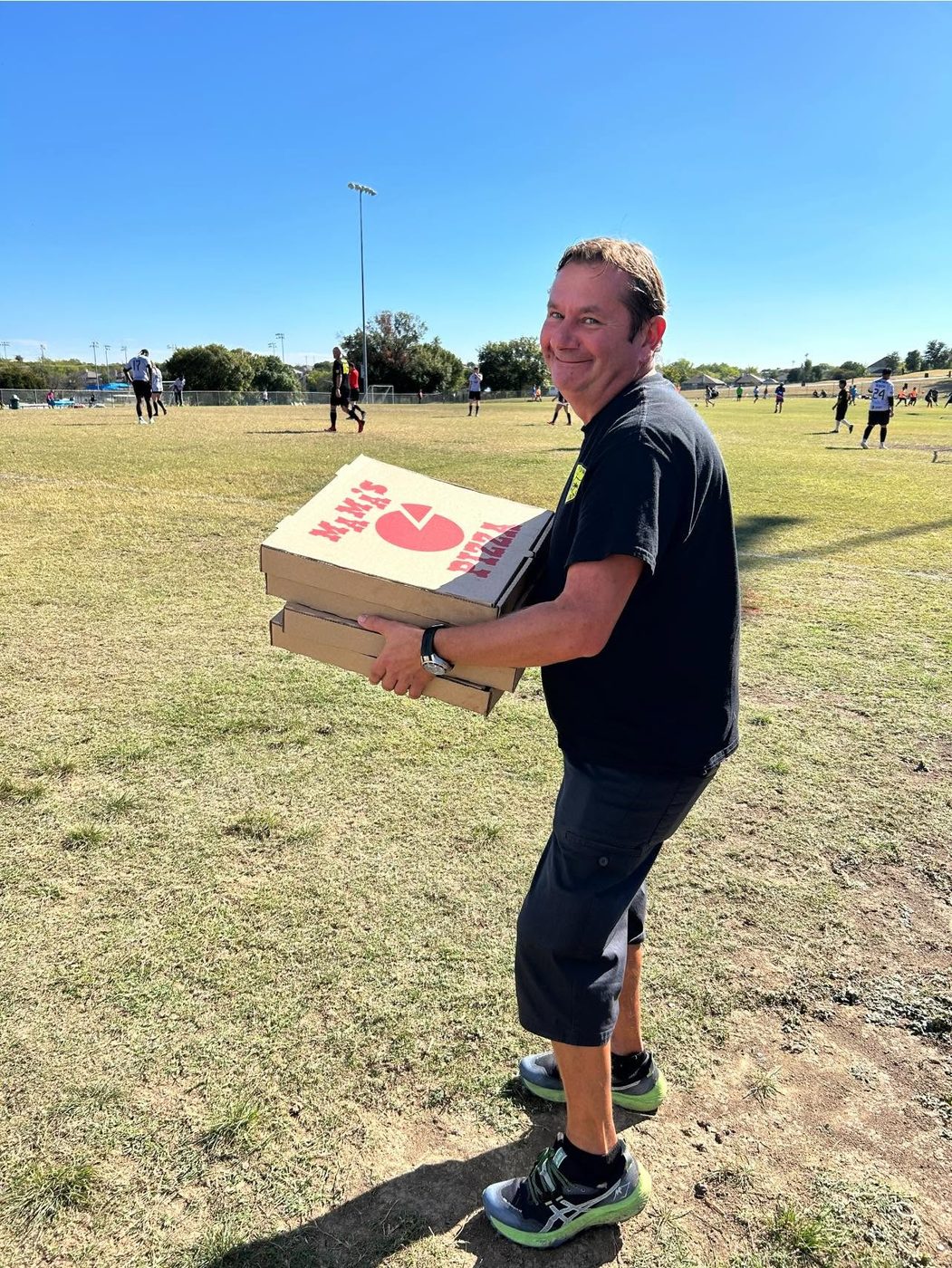 Marc at a Cowtown game day, carrying the pizzas.